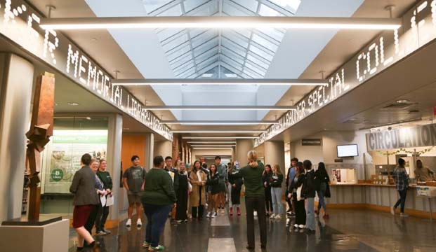 Group of people inside Baker Library listening to a tour guide