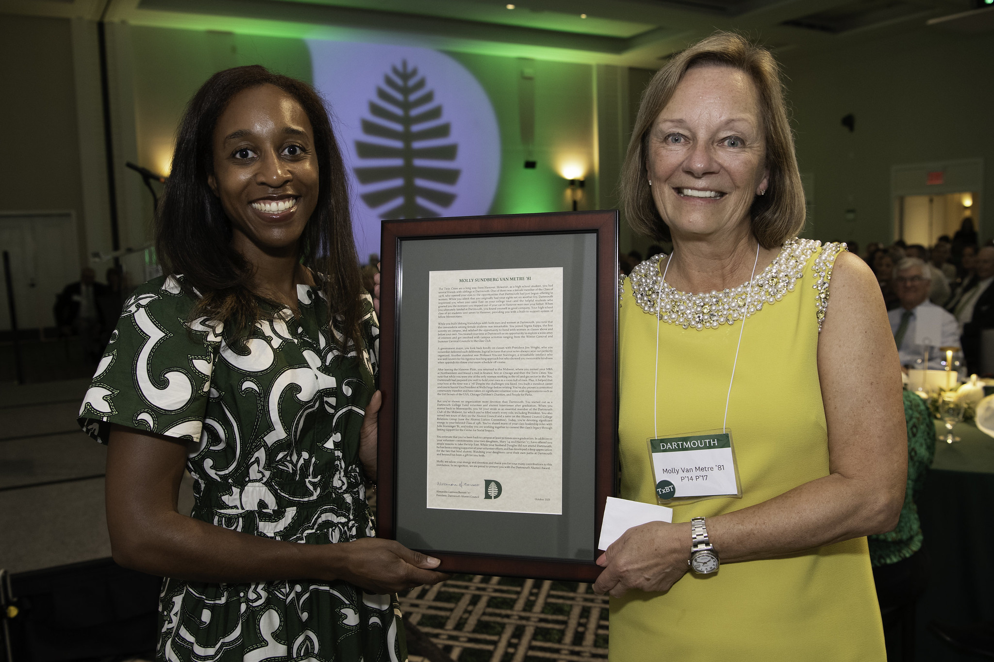 Alumni council president Alex Barnett holding an award with Molly Sundberg Van Metre