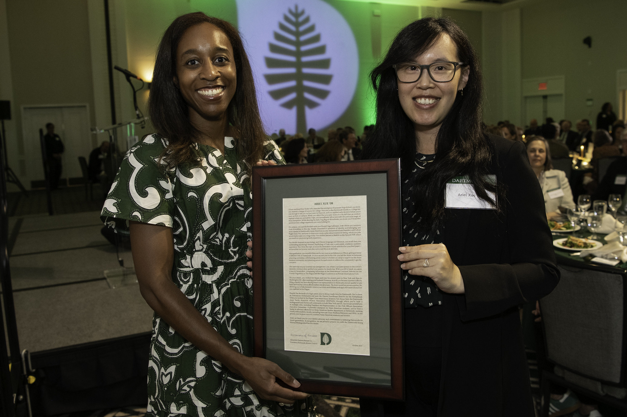 Alumni council president Alex Barnett holding an award with Ariel Xue