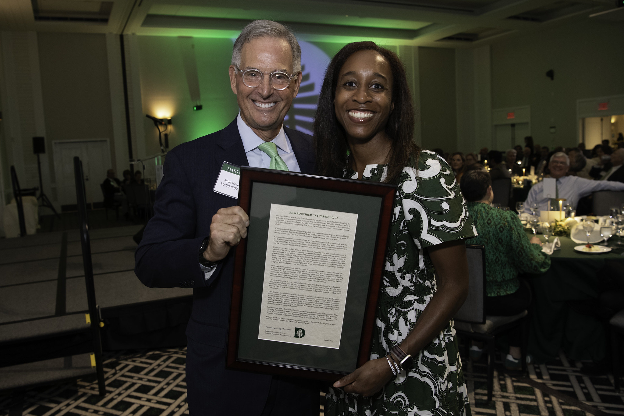 Alumni council president Alex Barnett holding an award with Rick Routhier