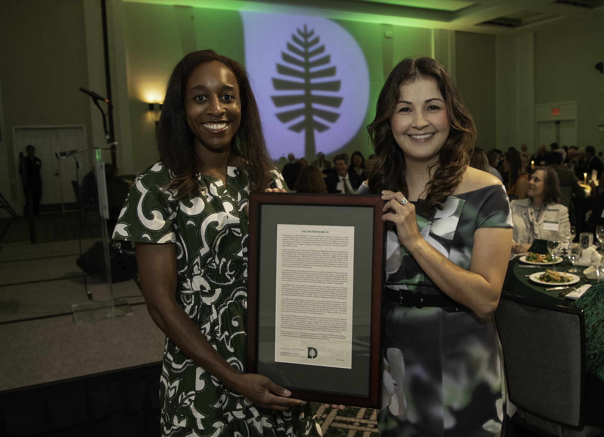 Alumni council president Alex Barnett holding an award with Kalina Newmark