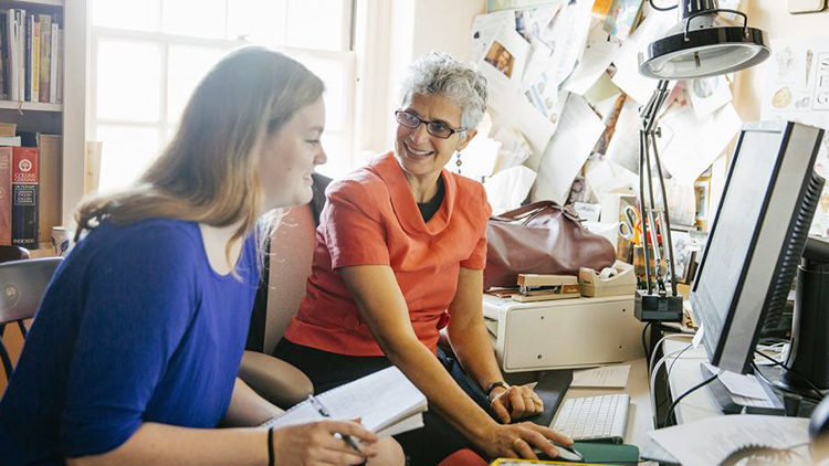 Photo of a faculty member speaking with a student during her office hours