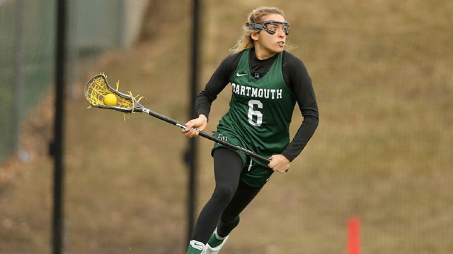 A women's lacrosse player cuts toward the net with the ball