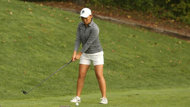 A golfer is in backswing on a put