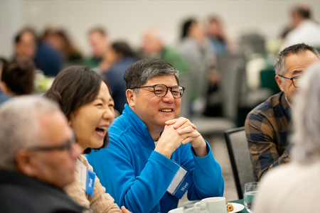 Man sitting at a table laughing