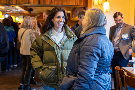 Two women in winter coats talking and smiling