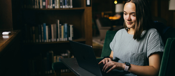 student in Dartmouth library on her computer