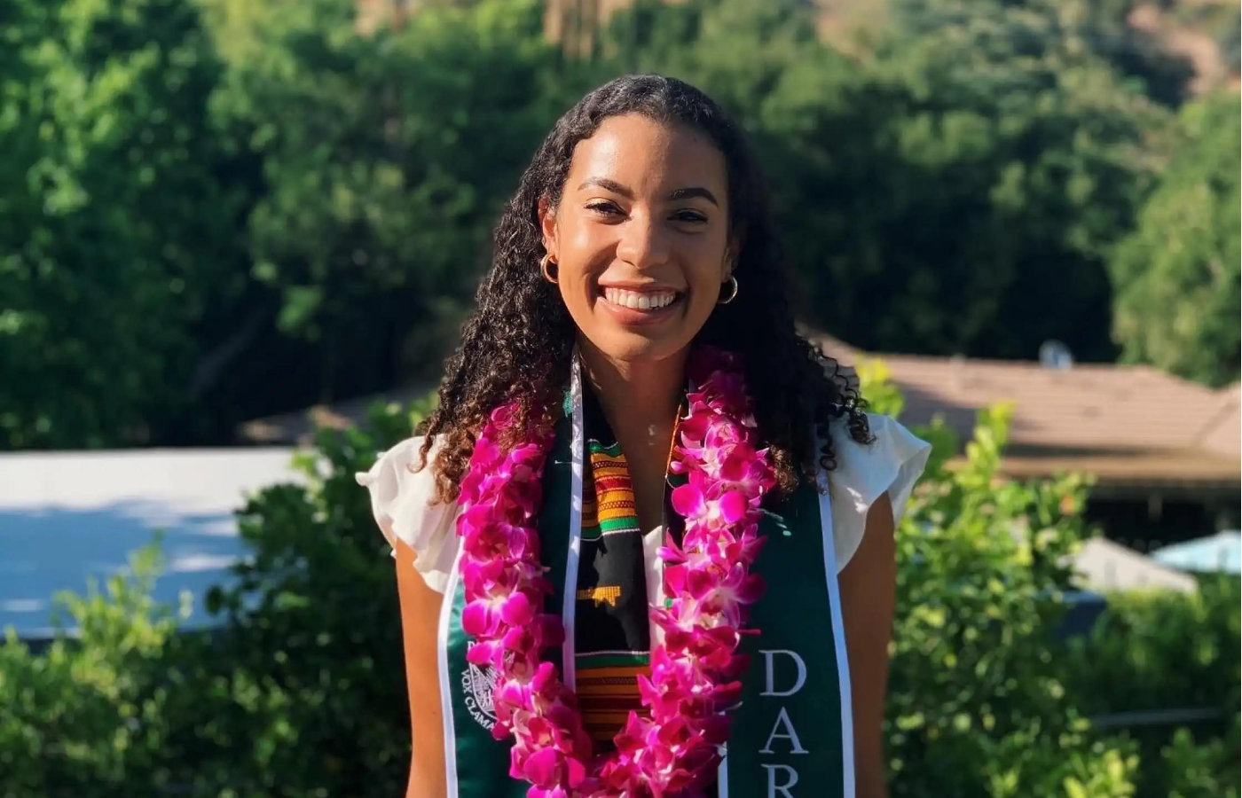 Lauren Jones '20 wearing a bright pink lei at commencement.