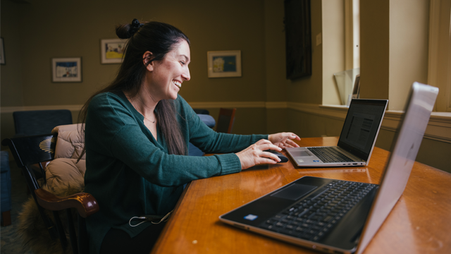 Woman smiling and working at her laptop