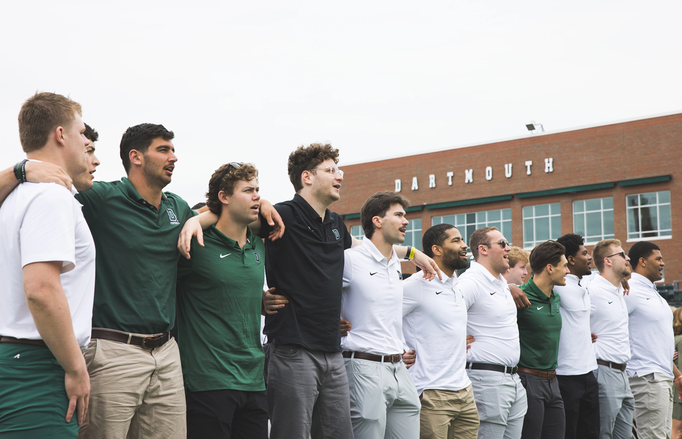 Football players arm in arm at the Buddy Teevens Celebration of Life